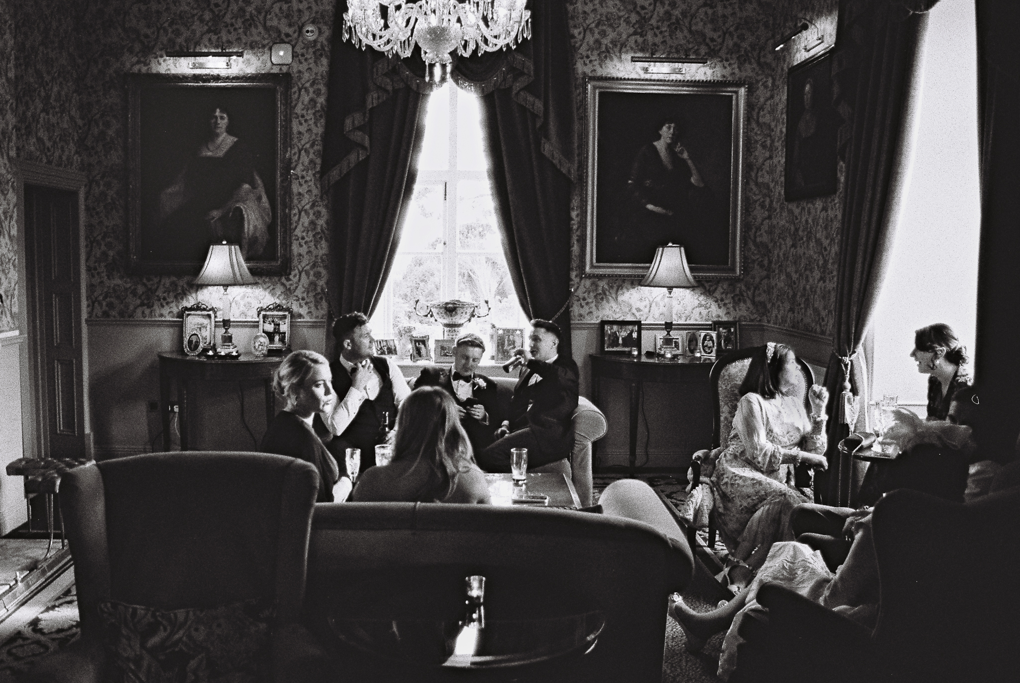 Black and white 35mm film photograph capturing wedding guests during the reception inside a historic room at Markree Castle in County Sligo, Ireland.