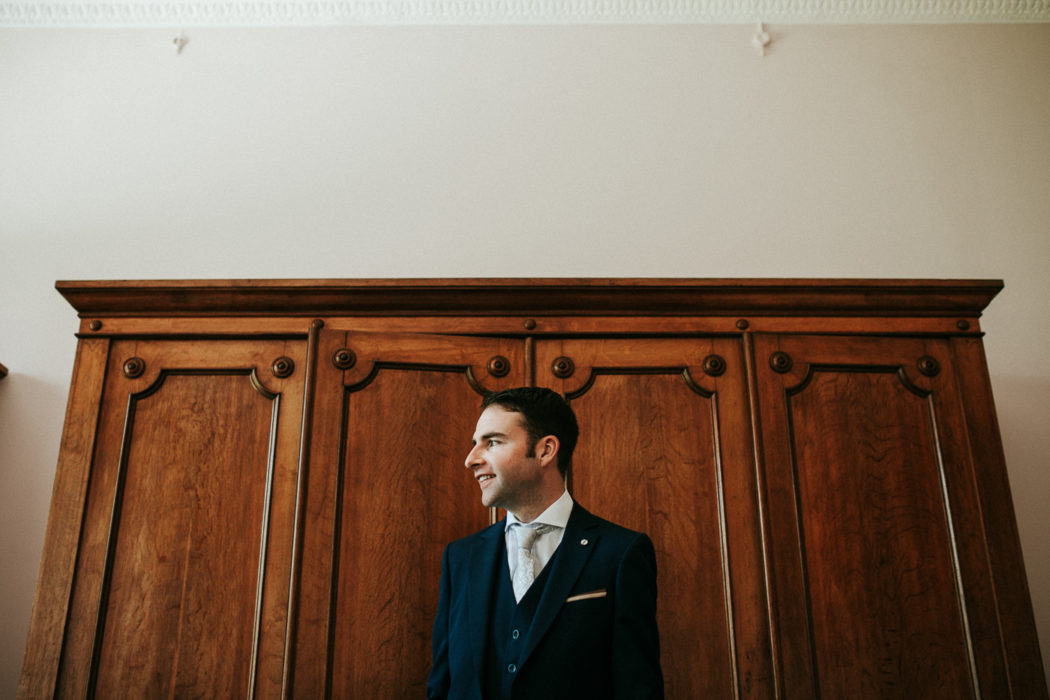 A man in a suit standing in front of a door