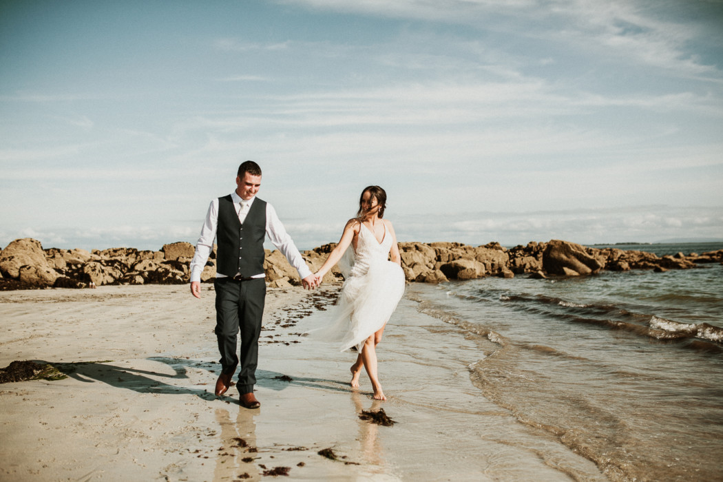 A man and a woman walking on a beach